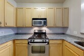 Located at 1200 N Herndon St in Arlington, VA, this two-story, 2-bedroom, 2-bathroom home offers a well-designed layout spread evenly across two floors. The main level welcomes you through a bright entrance with large windows and tiled flooring that transitions into warm light wood floors throughout. The open living and dining area is spacious and airy, with neutral tones and a staircase featuring classic wood railings leading to the upper floor. The kitchen is well-appointed with light maple cabinetry, granite-style countertops, stainless steel appliances including a gas range, built-in microwave, and dishwasher, offering ample storage and prep space. Upstairs, the bedrooms are generously sized, each with light wood flooring and large windows that invite natural light and outdoor views of the surrounding neighborhood. The primary bedroom includes a double-door closet for convenient storage. Both bathrooms are clean and functional, with one featuring a soaking tub and shower combination with white subway tile surround and mosaic tile flooring. Additional highlights include in-unit laundry, multiple closets throughout, a hallway, and two staircases for practical flow between floors.
