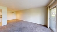 Located at 3307 Columbus Ave in Sandusky, Ohio, this single-floor, 2-bedroom, 2-bathroom home offers a functional and comfortable layout. The combined kitchen and living area forms the heart of the home, with the kitchen featuring white cabinetry, granite countertops, a stainless steel sink, tile flooring, recessed lighting, and white appliances including a refrigerator, range, microwave, and dishwasher. A pass-through opening connects the kitchen to the carpeted living room, which is brightened by large sliding glass doors that open to an outdoor view of the surrounding greenery, filling the space with natural light. Both bedrooms are carpeted and feature textured ceilings and windows that look out onto the landscaped exterior, providing a quiet, natural setting. The primary bedroom is generously sized and includes a closet with a wooden door. The two bathrooms are well-appointed, each with white fixtures; one features a granite-topped vanity with white cabinetry, a large mirror with pendant lighting, and a separate tub and shower room with tile flooring. The other includes a tub/shower combo with grab bars and a handheld showerhead. Neutral tones and carpet throughout the living spaces create a warm, cohesive ambiance.