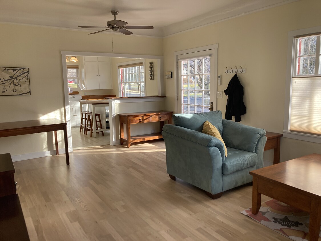 The bright and sunny great room features hard wood floors and comfy couches & chairs. - 831 Valencia St