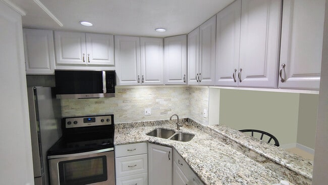Cocina remodelada en 2026 con encimeras de granito, electrodomésticos de acero inoxidable y detalles de iluminación especiales. - 1353 Pine Ridge Cir E