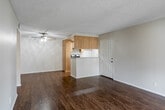Located in Chino Hills, CA, this 2-bedroom, 1-bathroom residence offers a practical and comfortable single-floor layout. The living room is a bright, open space featuring rich wood-style flooring, neutral walls, a textured ceiling, and a sliding glass door that opens onto a private balcony with outdoor views — an ideal spot for relaxing or enjoying the Southern California climate.

The kitchen is efficiently designed with light wood cabinetry, granite-style countertops, a gas range, a dishwasher, and a peninsula with a built-in sink that serves as a natural divider between the kitchen and living area. Recessed lighting and a tray ceiling detail add a polished touch to the cooking space.

Both bedrooms are carpeted for comfort and feature vertical blinds that allow for flexible light control. The primary bedroom includes mirrored sliding closet doors, maximizing the sense of space. The second bedroom benefits from dual windows, bringing in ample natural light. The shared full bathroom is clean and functional, offering a granite-style vanity countertop, a large wall mirror, and a shower-tub combination. A hallway connects the bedrooms and bathroom, completing the straightforward and well-organized floor plan.
