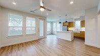 Located at 11464 Alamo Ranch Pkwy in San Antonio, TX, this well-appointed 2-bedroom, 2-bathroom home offers a thoughtfully designed single-level layout. The open-concept living, dining, and kitchen area is bright and welcoming, featuring light wood-style flooring, recessed lighting, and ceiling fans throughout. Large windows dressed with blinds invite generous natural light into every room.

The kitchen is a standout feature, showcasing flat-front light wood cabinetry, crisp white quartz countertops, a farmhouse sink, white subway tile backsplash with under-cabinet lighting, stainless steel appliances, and a central island illuminated by two stylish pendant lights. The space flows seamlessly into the dining and living areas, making it ideal for entertaining.

The primary bedroom is generously sized, complete with a ceiling fan and en-suite bathroom. The primary bath features a long wood-toned vanity with dual sinks, a glass-enclosed shower, and direct access to a walk-in closet with built-in shelving. The second bedroom is well-proportioned with ample natural light. Additional highlights include multiple closets, a dedicated laundry area, a utility room, and a private balcony. Clean, modern finishes give the space a fresh and contemporary feel throughout.