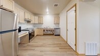 Located at 543 N Alexander in Ellsworth, Wisconsin, this 2-bedroom, 1-bathroom unit offers a practical and modern layout across a single floor. Light hardwood-style flooring and warm wood-trimmed doorways run throughout, creating a cohesive and clean aesthetic.

The open-concept kitchen and living area serves as the heart of the unit. The kitchen is well-equipped with light maple cabinetry, marble-style countertops, stainless steel appliances including a refrigerator, electric range, and dishwasher, plus a dedicated pantry for additional storage. Ceiling fans in the living and bedroom areas provide year-round comfort.

Both bedrooms are comfortably sized and feature natural light from windows with outdoor views, ceiling fans, and generous closet space with double bi-fold doors. The primary bedroom is spacious and includes its own closet. A total of three closets are distributed throughout the unit for ample storage.

The bathroom is designed with accessibility in mind, featuring grab bars near the toilet and shower area, and continuing the light flooring found throughout the home. A dedicated laundry area and in-unit storage add further convenience. The unit's clean, neutral palette and modern finishes make it a functional and inviting living space.