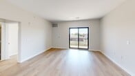 This well-appointed 3-bedroom, 2-bathroom residence at 301 Memorial Dr in Neptune, NJ offers a thoughtfully designed single-floor layout with a clean, modern aesthetic throughout. Light wood flooring flows seamlessly across the open-plan kitchen and living area, creating a bright and cohesive atmosphere. The kitchen is equipped with stainless steel appliances, including a gas range, microwave, and refrigerator, complemented by light wood cabinetry, a tiled backsplash, and dark granite countertops that extend to a peninsula with an undermount sink — ideal for both meal prep and casual dining. The spacious living area opens directly to a private balcony through sliding glass doors, allowing for natural light and outdoor views. The generously sized primary bedroom features built-in closet space and its own en-suite bathroom, which boasts a dual-sink vanity with granite countertops, light wood cabinetry, a lighted mirror, and large-format tile flooring. The second bathroom mirrors the same refined finishes with a single vanity and shower. The two additional bedrooms are bright and versatile, each with light wood flooring and windows bringing in natural light. A connecting hallway ties all spaces together efficiently, completing this well-designed home.