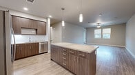 Located at 511 Carlson Ave in Rohnert Park, CA, this single-story home offers four bedrooms, three bathrooms, and an attached garage. The modern kitchen serves as a central highlight, featuring dark wood-tone cabinetry reaching to the ceiling, stainless steel appliances including a refrigerator, range, microwave, and dishwasher, a white tile backsplash, and a large center island with a quartz-style countertop illuminated by sleek pendant lighting. Light wood-look flooring flows through the kitchen and into the open living area, which benefits from recessed lighting, a ceiling fan, and windows that allow natural light to fill the space.

The four bedrooms are finished with neutral carpet and soft neutral-toned walls. The spacious primary bedroom provides a comfortable retreat, while the remaining bedrooms offer versatile configurations with ample natural light. The three bathrooms maintain a consistent modern aesthetic, featuring wood-tone vanities, light countertops, large mirrors, and combination tub/shower units with clean white surrounds on light wood-look flooring. The attached garage includes an automatic opener and paneled door with windows, providing convenient and secure parking.
