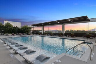 Resort-style pool with lounge seating and sun shade - AMLI Arts Center
