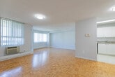 Located at 1477 Mississauga Valley Blvd in Mississauga, Ontario, this one-bedroom, one-bathroom unit offers a well-organized layout across a single floor. The living room is a generous, open space highlighted by warm parquet hardwood flooring that runs throughout the unit, large windows dressed with vertical blinds, and a textured ceiling. The abundance of natural light and corner window placement create a bright, airy atmosphere, with views of the surrounding neighbourhood. A wall-mounted air conditioning unit provides in-suite climate control.

The kitchen is thoughtfully arranged with white cabinetry offering ample storage, a double-basin sink, a full-size electric range, and a refrigerator. Light-toned tile flooring and a skylight overhead keep the space feeling clean and bright. A partial wall with a pass-through counter connects the kitchen to the living area, maintaining an open feel while defining each zone.

The bedroom is a comfortable, well-proportioned room featuring the same classic parquet flooring, neutral walls, a closet, and a window with vertical blinds that brings in natural light. The bathroom is finished with clean white tile surrounding a full bathtub and shower combination, maintaining a simple and functional aesthetic throughout.