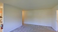 This single-floor space offers a clean, move-in-ready interior with a simple and functional layout. The main living area is finished with wall-to-wall neutral-toned carpet that provides a soft, comfortable underfoot experience throughout. The walls are painted in a light, warm off-white tone that reflects available light and contributes to a bright, open ambiance. Smooth, standard-height ceilings give the space a comfortable and approachable feel. The room features clean white baseboards that provide a crisp contrast against the flooring, adding a subtle but polished finishing detail. The overall aesthetic is understated and versatile, making it well-suited for a variety of interior design styles. The minimalist presentation of the space allows prospective occupants to clearly assess the dimensions and flow of the layout without distraction. The interior's neutral palette serves as a blank canvas, offering flexibility for customization and decoration. The space is well-maintained with no visible wear, presenting a tidy and welcoming environment throughout.