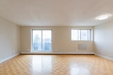 Located at 57 Union St E in Waterloo, Ontario, this 2-bedroom, 2-bathroom unit is thoughtfully laid out across a single floor. The entrance leads through a hallway into the heart of the home, where warm parquet hardwood flooring flows consistently throughout the living spaces, lending a timeless character to the interior.

The kitchen is clean and functional, featuring white shaker-style cabinetry, a classic white subway tile backsplash, grey countertops with a double stainless steel sink, and stainless steel appliances including an electric range and refrigerator. Light tile flooring completes the space. Adjacent to the kitchen, the spacious living room is brightened by a large sliding glass door that allows natural light to fill the room.

The primary bedroom is generously sized and offers access to a full ensuite bathroom, providing added privacy and convenience. The second bedroom features its own window with views of the surrounding neighbourhood and includes a built-in closet with bifold doors for ample storage. Both bedrooms continue the parquet flooring found throughout the unit. The bathrooms are finished with clean white tile, with one featuring a full tub-shower combination with grab bar support. A dedicated closet and hallway round out the layout, adding practical storage to this well-organized home.