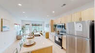 Located at 47 William Howard Taft Rd in Cincinnati's Corryville neighborhood, this thoughtfully designed residence offers four bedrooms and four bathrooms across a single floor. The open-concept layout seamlessly connects the kitchen and living room, creating a bright, communal hub at the heart of the home. The kitchen is well-appointed with light wood cabinetry, stainless steel appliances including a refrigerator, range, and microwave, a tiled backsplash, and a central island with seating — ideal for both cooking and casual dining. The adjacent living area provides a welcoming retreat with neutral tones and access to a private balcony. Each of the four bedrooms offers a clean, minimalist aesthetic with light flooring, ample closet space, and access to natural light; select rooms include windows with exterior views of the surrounding neighborhood. The four bathrooms maintain a consistent modern style, each featuring light wood vanities with white countertops and a bathtub/shower combination. A dedicated in-unit laundry room houses a full-size washer and dryer. Multiple hallways connect the rooms efficiently, and a utility room adds practical storage. Light-toned flooring, recessed lighting, and crisp white walls run throughout, creating a cohesive, contemporary ambiance.