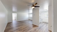 Located at 318 N Sage St in Kalamazoo, Michigan, this well-appointed one-bedroom, one-bathroom unit offers a practical and comfortable layout across a single floor. The living room greets you with clean white walls, modern wood-look vinyl plank flooring, a large window that invites natural light, and a wall-mounted air conditioning unit alongside baseboard heating for year-round comfort.

The kitchen is efficiently designed with gray shaker-style cabinetry lining both walls, a light laminate countertop, and a white electric range with an overhead vent. A centrally positioned window provides natural light and a view of the outdoors, enhancing the functionality of the space.

The bedroom offers plush beige carpeting and features a striking set of bold black double closet doors, providing ample storage. Black interior doors carry throughout the unit, adding a consistent design accent against the neutral white walls. A window with blinds allows natural light into this comfortable retreat.

The hallway connects the rooms seamlessly, leading to the full bathroom, which is finished with wood-look flooring, a white tub and shower surround, a toilet, and a window for ventilation and natural light. The overall ambiance of the unit is clean, neutral, and move-in ready, offering a functional and tidy living environment.