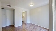 This well-organized 2-bedroom, 2-bathroom single-floor home offers a practical and comfortable layout designed to maximize every square foot. The living room serves as the central gathering space, featuring durable wood-style flooring and a sliding glass door fitted with vertical blinds that allow an abundance of natural light to fill the room. The galley-style kitchen is efficiently arranged with white cabinetry on both sides, a double-basin sink with granite-style countertops, a white electric range, and a full-size refrigerator — providing ample storage and workspace. Both bedrooms are finished with plush carpeting and include windows with vertical blinds for light control and privacy. The primary bedroom offers generous proportions and includes two closets, adding practical storage. The two bathrooms are clean and functional, each featuring wood-style flooring, white vanity cabinetry with granite-style countertops, and mirrored medicine cabinets. One bathroom includes a bathtub with shower fixtures. A connecting hallway ties the private areas of the home together seamlessly. The neutral color palette and consistent finishes throughout create a cohesive, move-in-ready environment well-suited for comfortable everyday living.
