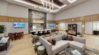This 4,920 square foot, single-floor property at 5401 W Northgate Rd, Rogers, AR, showcases a blend of contemporary design and luxury amenities. The space is characterized by its open-plan layout and high ceilings, enhanced by innovative lighting solutions including sculptural chandeliers and recessed fixtures. Large windows flood the areas with natural light and offer views of the surrounding landscape.

The main lounge area is a focal point, featuring a dramatic floor-to-ceiling stone fireplace, comfortable seating arrangements, and a striking artistic light fixture. Adjacent spaces include a modern kitchen area with bar seating, multiple seating nooks, and a game room. The interior design maintains a cohesive neutral color palette with pops of color in furnishings and artwork.

Throughout the property, high-end finishes are evident, from the light wood flooring to the custom millwork and built-in shelving. The space incorporates various textures and materials, including stone, wood, glass, and metallic accents, creating a rich, layered aesthetic. Thoughtfully placed artwork and decorative elements add personality to each area.

Additional amenities appear to include a fitness center and possibly office or meeting spaces, though these are not fully visible in the provided images. The property's design emphasizes comfort, style, and functionality, catering to a modern, upscale lifestyle.
