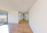 Located at 7007 Inglewood Ave in Stockton, California, this single-floor unit presents a clean and functional layout designed for comfortable everyday living. The open living area features light wood-style flooring that extends throughout the space, crisp white walls, and a textured ceiling that adds subtle character. Natural light flows generously through large sliding glass doors that lead to a private outdoor patio, offering views of the surrounding neighborhood greenery and a seamless indoor-outdoor connection.

The kitchen is efficiently arranged with white cabinetry, ample counter space, a built-in electric range, an under-cabinet range hood, and a dishwasher. A window above the counter brings in natural light, keeping the workspace bright and airy. A full-size refrigerator is also included.

The bedroom is a well-proportioned, sunlit room with the same wood-style flooring and a wall-mounted air conditioning unit for year-round comfort. The bathroom is outfitted with a tub-shower combination featuring marble-style surround panels, a vanity with a light stone countertop, and a large mirror. Additional rooms provide flexible living or storage options. The exterior of the building features a neutral stucco finish with a pitched shingle roof and maintained landscaping.