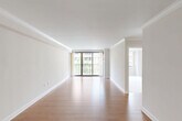 Located in Washington, DC's desirable West End neighborhood, this one-bedroom, one-bathroom residence offers a well-designed layout across a single floor. The spacious living room is a standout feature, showcasing warm hardwood flooring, crown molding, and a wall of sliding glass doors that open to a private balcony with outdoor views, flooding the space with natural light. The kitchen is efficiently appointed with warm wood cabinetry, granite countertops, a textured tile backsplash, and a full suite of stainless steel appliances including a range, microwave, and refrigerator. The bedroom features plush carpeting, crown molding, and large windows that frame views of the surrounding neighborhood, while a dedicated closet provides ample storage. The bathroom is tastefully updated with granite countertops on a white vanity, large-format tile flooring, and a glass-enclosed walk-in shower accented with a decorative mosaic tile border. Throughout the residence, clean white walls, crown molding, and consistent finishes create a cohesive and polished aesthetic that is both functional and inviting.
