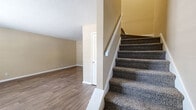 Located at 2900 E North St in Greenville, SC, this two-story, 3-bedroom, 2-bathroom home offers a well-designed layout spread evenly across two floors. The main level features a welcoming living area with wood-look flooring and a thermostat-controlled climate system. The kitchen is a standout, outfitted with dark espresso cabinetry, granite-look countertops, a tile backsplash, and a full suite of stainless steel appliances including a refrigerator, range, microwave, and dishwasher. A window over the sink brings in natural light. A dedicated laundry room with a full-size washer and dryer adds everyday convenience. Both bathrooms feature tub-shower combinations with bold slate-style tile surrounds and wood-look flooring. The bedrooms are carpeted and bright, with ceiling fans and windows that let in natural light. The spacious primary bedroom includes a closet and connects to additional rooms. Secondary bedrooms offer comfortable proportions, also with ceiling fans. Textured ceilings are consistent throughout. The home's practical two-floor layout provides distinct living and sleeping zones, making it a functional and comfortable residence in Greenville.