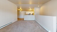 Located at 2124 Kennedy Dr in New Holstein, Wisconsin, this two-story residence offers three bedrooms, two full bathrooms, and a thoughtfully organized layout spread across two floors. The main level provides a compact yet functional entry point, while the upper floor houses the majority of the living space, including the primary living areas and bedrooms.

The open-concept kitchen and dining area is a highlight of the upper floor, featuring white cabinetry, granite-style countertops, stainless steel appliances including a range, microwave, and refrigerator, and light wood-style flooring that adds warmth throughout. A peninsula countertop provides additional prep space and a natural divider between the kitchen and the adjoining living room, which is finished with plush carpeting.

The generously sized primary bedroom offers ample room and includes a wall-mounted air conditioning unit and baseboard heating. The additional bedrooms are carpeted and well-proportioned. Both bathrooms are finished with white cabinetry, granite-style vanity tops, and wood-style tile flooring, with one featuring a shower-tub combination. A dedicated laundry room with wire shelving adds everyday convenience. Sliding glass doors open to a private balcony with exterior views, and carpeted staircases connect the two levels seamlessly.