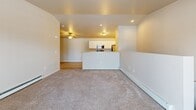 Located at 2124 Kennedy Dr in New Holstein, Wisconsin, this two-story residence offers three bedrooms, two full bathrooms, and a thoughtfully organized layout spread across two floors. The main level provides a compact yet functional entry point, while the upper floor houses the majority of the living space, including the primary living areas and bedrooms.

The open-concept kitchen and dining area is a highlight of the upper floor, featuring white cabinetry, granite-style countertops, stainless steel appliances including a range, microwave, and refrigerator, and light wood-style flooring that adds warmth throughout. A peninsula countertop provides additional prep space and a natural divider between the kitchen and the adjoining living room, which is finished with plush carpeting.

The generously sized primary bedroom offers ample room and includes a wall-mounted air conditioning unit and baseboard heating. The additional bedrooms are carpeted and well-proportioned. Both bathrooms are finished with white cabinetry, granite-style vanity tops, and wood-style tile flooring, with one featuring a shower-tub combination. A dedicated laundry room with wire shelving adds everyday convenience. Sliding glass doors open to a private balcony with exterior views, and carpeted staircases connect the two levels seamlessly.