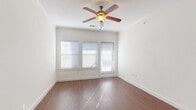 This single-story residence at 1309 Winkler Ave in Killeen, Texas, presents a clean, functional layout across several well-defined living spaces. The main living area is bright and open, featuring warm wood-look flooring, crown molding, and a ceiling fan with a light fixture overhead. Multiple windows dressed with horizontal blinds allow natural light to filter into the room, creating an airy and inviting atmosphere. A door from this space provides exterior access.

The kitchen is positioned adjacent to the living area and is defined by a peninsula counter that offers both workspace and a visual separation between the two zones. Dark cabinetry with light countertops provides practical storage, complemented by built-in appliances including a range and microwave. Track lighting adds functional illumination to the space.

The bedrooms are carpeted and feature crisp white walls, generous closet space with built-in shelving and rods, and ample room for furnishings. The hallway connecting these private areas is also carpeted and leads conveniently to the bathrooms.

Both bathrooms are finished with wood-look flooring, dark vanity cabinetry, light countertops, large mirrors, and a tub-shower combination surrounded by white tile, maintaining a consistent and cohesive design throughout the home.