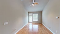 Located at 4240 N Fern Creek Pl in Fayetteville, Arkansas, this single-floor residence offers a thoughtfully designed layout with a clean, neutral aesthetic throughout. The main living area is a standout feature, showcasing soaring vaulted ceilings that amplify the sense of space, gleaming hardwood floors, and a ceiling fan with integrated lighting. Natural light flows in through a glass door and adjacent window fitted with blinds, creating a bright and airy atmosphere. The open layout connects seamlessly to other areas of the home, including a hallway leading to additional rooms. The kitchen is well-appointed with dark granite countertops, white cabinetry, a tile backsplash, stainless steel sink, and tile flooring, offering both functionality and style. Bedrooms are carpeted for comfort, with neutral tones and ample natural light from large windows with blinds. The primary bedroom includes a spacious walk-in closet with built-in shelving, while a secondary bedroom features a standard closet with rod storage. The bathroom is finished with granite countertops, tile flooring, and a full tub-shower combination. Throughout, the home maintains a cohesive, move-in-ready appeal with consistent finishes and practical design.