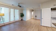 This single-floor unit at 7084 Friars Road, #519 in San Diego offers a thoughtfully designed layout with a clean, contemporary aesthetic throughout. Neutral-toned walls and light wood-look flooring flow consistently across the main living areas, creating a cohesive and bright atmosphere. Crown molding adds a refined architectural detail to the main living space, which is further enhanced by a ceiling fan and full-length glass doors that invite natural light and provide access to an outdoor area with greenery views.

The galley-style kitchen is equipped with white cabinetry, dark granite countertops, stainless steel appliances including a French door refrigerator and dishwasher, and a double-basin sink — offering both style and functionality. A dedicated dining or flex room features track lighting and a mirrored accent wall, adding depth and versatility to the space.

The bedrooms are carpeted for comfort, with windows providing natural light. A walk-in closet with wire shelving systems offers generous organizational storage. Two bathrooms include white vanities with dark granite countertops; one features a tub-shower combination, while the other includes a single vanity with ample cabinet space. The overall design is clean, neutral, and move-in ready.