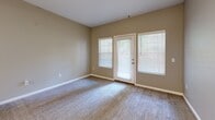 Located in Lakewood, Colorado, this one-bedroom, one-bathroom residence offers a well-organized single-floor layout designed for comfortable everyday living. The open-concept kitchen and living area serves as the heart of the home, featuring a peninsula island with a built-in sink, stainless steel appliances including a refrigerator, range, and microwave, and crisp white cabinetry with light countertops. Wood-style hard flooring runs throughout the kitchen and living areas, while a ceiling fan adds both function and style. The living room benefits from natural light streaming through multiple windows and a glass exterior door, creating a bright and welcoming atmosphere. The bedroom is a comfortable, carpeted retreat with neutral tones and ample wall space. The bathroom includes a full tub-and-shower combination with white tile surround, a vanity with storage, and wood-style flooring. A dedicated laundry closet houses an in-unit washer and dryer with overhead shelving for added storage. A hallway and closet complete the layout, ensuring practical storage throughout. The consistent warm-gray color palette and clean finishes lend the space a cohesive, move-in-ready feel.