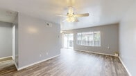 Located at 201 Los Arbolitos Boulevard in Oceanside, CA, this single-story, one-bedroom, two-bathroom residence offers a well-organized and efficiently designed layout. Wood-look plank flooring runs throughout the entire space, lending warmth and visual continuity to every room.

The open-concept kitchen and living area serves as the heart of the home. The kitchen features white cabinetry with ample drawer and cabinet storage, a single-basin sink, a dishwasher, and a breakfast bar — all oriented toward the adjoining living room. The living room is bright and airy, with large windows and a sliding glass door that invite natural light and provide access to the outdoors. A ceiling fan with integrated lighting anchors the space above.

The bedroom is a comfortable and well-proportioned retreat, equipped with its own ceiling fan, a window for natural light, and a full wall of mirrored sliding closet doors that enhance the sense of space. The two bathrooms serve the home effectively: one features a full tub-shower combination with clean white surroundings, while the other offers a wide vanity with white cabinetry, a large mirror, and modern light fixtures.

Neutral gray wall tones throughout create a clean, cohesive aesthetic, while the entrance provides a smooth transition into the main living areas. The overall ambiance is light, functional, and move-in ready.