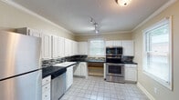 Located at 195 Willow Bend Ct in Kernersville, NC, this single-story home offers a thoughtfully designed layout with a variety of functional spaces. The kitchen is a standout feature, showcasing white cabinetry with raised-panel doors, dark granite-style countertops, a mosaic tile backsplash, and a full suite of stainless steel appliances including a range, microwave, dishwasher, and refrigerator. Light tile flooring and multiple windows allow natural light to fill the space. Crown molding adds a refined touch throughout the kitchen and main living areas. The living and dining areas feature rich hardwood flooring and are brightened by natural light from windows and a sliding glass door that opens to the backyard. Crown molding continues to enhance these spaces, lending a polished, cohesive aesthetic. The bedrooms are carpeted for comfort, each equipped with a ceiling fan and windows offering views of the surrounding greenery. The bathroom is designed with accessibility in mind, featuring grab bars, a tub/shower combination, tile flooring, and a wall-mounted sink. A textured ceiling is present throughout the home, adding depth to the overall interior character. This home combines practical design with comfortable living in a quiet Kernersville neighborhood.