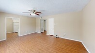 Located at 11850 Wentling Ave in Baton Rouge, Louisiana, this 2-bedroom, 2-bathroom residence offers a functional and comfortable single-floor layout. The living room serves as the heart of the home, featuring warm wood-look laminate flooring, a ceiling fan with light fixture, and a large window fitted with blinds that allows natural light to fill the space. A front entry door opens directly into this welcoming area.

The kitchen is efficiently designed with white cabinetry, a full-size refrigerator, a double-basin sink, and laminate flooring that continues the cohesive aesthetic of the main living areas. A hallway connects the living spaces to the bedrooms and bathrooms.

Both bedrooms are carpeted for added comfort and are equipped with ceiling fans. Each room features windows with outdoor views and generous closet space, including a sliding double-door closet in the primary bedroom. The primary bedroom offers a comfortable, private retreat.

The two bathrooms are clean and straightforward in design. One features a tub-shower combination with a curved curtain rod, while the other includes a vanity with a light countertop and wood-look flooring. Neutral beige tones and textured ceilings are consistent throughout the entire unit, creating a cohesive and understated aesthetic.
