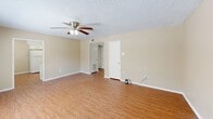 Located at 11850 Wentling Ave in Baton Rouge, Louisiana, this 2-bedroom, 2-bathroom residence offers a functional and comfortable single-floor layout. The living room serves as the heart of the home, featuring warm wood-look laminate flooring, a ceiling fan with light fixture, and a large window fitted with blinds that allows natural light to fill the space. A front entry door opens directly into this welcoming area.

The kitchen is efficiently designed with white cabinetry, a full-size refrigerator, a double-basin sink, and laminate flooring that continues the cohesive aesthetic of the main living areas. A hallway connects the living spaces to the bedrooms and bathrooms.

Both bedrooms are carpeted for added comfort and are equipped with ceiling fans. Each room features windows with outdoor views and generous closet space, including a sliding double-door closet in the primary bedroom. The primary bedroom offers a comfortable, private retreat.

The two bathrooms are clean and straightforward in design. One features a tub-shower combination with a curved curtain rod, while the other includes a vanity with a light countertop and wood-look flooring. Neutral beige tones and textured ceilings are consistent throughout the entire unit, creating a cohesive and understated aesthetic.