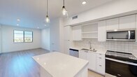 Located in Royal Palm Beach, FL, this thoughtfully designed one-bedroom, one-bathroom residence offers a clean, modern aesthetic throughout. Light wood-look flooring flows seamlessly across the entire space, complementing the bright white walls and creating a warm, airy ambiance.

The open-concept kitchen and living area forms the heart of the home. The kitchen is outfitted with sleek white flat-panel cabinetry, open shelving, a classic square-tile backsplash, stainless steel appliances — including a range, microwave, dishwasher, and refrigerator — and a striking white quartz island topped with stylish pendant lighting. The adjacent living area provides a generous, flexible space bathed in natural light.

The bedroom is a comfortable retreat featuring a ceiling fan, a window with outdoor views of the surrounding waterway and community, and access to a private balcony that extends the living space outdoors. Two closets provide ample storage, and an in-unit laundry area adds everyday convenience.

The bathroom is finished in crisp white tile with subtle horizontal accent banding, a soaking tub and shower combination, a floating vanity with clean-lined drawers, and a backlit mirror. Every detail reflects a modern, move-in-ready design ideal for comfortable Florida living.