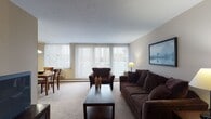 Located at 25151 Brookpark Rd in North Olmsted, Ohio, this single-floor residence offers a well-organized and functional layout across several distinct living areas. The open living room is a welcoming centerpiece, featuring plush wall-to-wall carpeting, neutral-toned walls, and expansive floor-to-ceiling vertical blinds that invite generous amounts of natural light while offering views of the surrounding neighborhood. The adjacent dining area flows seamlessly from the living room, complete with a pendant chandelier overhead and the same large windows that brighten the space throughout the day. The kitchen is thoughtfully appointed with white cabinetry offering ample storage, a full suite of appliances including a refrigerator and electric range, a stainless steel sink, and warm hardwood flooring that adds a touch of character. The bedroom provides a comfortable retreat, highlighted by a bold accent wall, a large window with outdoor views, and a roomy closet with built-in shelving and hanging space. The bathroom features classic white tile wainscoting, a vanity with under-sink storage, a mirrored medicine cabinet, and a shower-tub combination. Together, these spaces form a cohesive, practical, and comfortable home.
