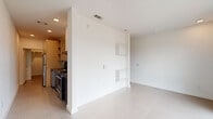Located at 701 S School Ave in Fayetteville, Arkansas, this thoughtfully designed one-bedroom, one-bathroom unit offers a compact yet efficient layout across a single floor. The living area greets residents with large windows that flood the space with natural light and offer views of the surrounding neighborhood. Built-in wall shelving provides practical storage and a modern design accent, while recessed lighting and clean white walls contribute to a bright, contemporary ambiance.

The kitchen is efficiently appointed with sleek, dark cabinetry, concrete-style countertops, a stainless steel undermount sink, an electric range with a ventilation hood, and a matching dark tile backsplash—creating a cohesive, modern aesthetic in a compact footprint.

The bedroom is a comfortable, carpeted room fitted with a ceiling fan and light fixture, offering a cozy retreat. A dedicated closet provides additional storage. The bathroom maintains the unit's modern design language with a dark vanity, dark countertop, an illuminated mirror, and clean white walls.

A notable feature is the in-unit stacked washer and dryer, visible in the floor plan. Throughout the unit, neutral tones, minimalist finishes, and an efficient use of space define the overall character of this well-designed Fayetteville residence.