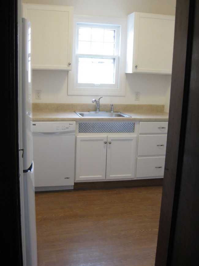 Kitchen showing fridge, dishwasher and sink - Kenmore Estates Apartments