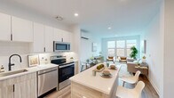 This thoughtfully designed one-bedroom, one-bathroom residence at 103 Hamilton Street in Bound Brook, NJ offers a clean, modern aesthetic with an efficient and well-organized floor plan. The open-concept living and kitchen area serves as the heart of the home, where light wood-tone flooring, recessed lighting, and a bright, neutral color palette create a welcoming and airy atmosphere. The kitchen is equipped with stainless steel appliances, white upper cabinetry paired with warm wood-toned lower cabinets, a white quartz countertop, and a central island that provides additional prep space and casual dining. A wall-mounted split unit ensures year-round climate comfort. The living room benefits from a large picture window that fills the space with natural light and offers views of the surrounding neighborhood. The bedroom features two generously sized windows, continuing the theme of natural light, with ample room for a full furniture arrangement. The bathroom is finished with a wood-vanity, white quartz countertop, and light tile flooring for a clean, spa-like feel. Additional conveniences include two closets, an in-unit laundry area, and a utility room, rounding out this well-appointed residence.