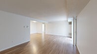 This single-floor, one-bedroom, one-bathroom residence at 41 Eastview Dr in Milford, MA offers a well-organized layout across a comfortable footprint. The living area features smooth hardwood-style flooring that reflects natural light, neutral white walls, and a textured ceiling. A sliding glass door fitted with vertical blinds opens to an outdoor view, filling the space with natural light and providing seamless indoor-outdoor connectivity. An additional section of the living area offers versatile open space, also finished with hardwood-style flooring and accented by a standard entry door.

The kitchen is equipped with warm oak cabinetry offering ample upper and lower storage, light-toned countertops, a stainless steel dishwasher, electric range, and a refrigerator, all set on hardwood-style flooring. The generously sized primary bedroom is carpeted for comfort and features a large window with leafy outdoor views, along with access to multiple closets for abundant storage.

The bathroom includes a full-sized soaking tub with a shower, white surround walls, and a vanity with sink. A hallway connects the rooms efficiently, contributing to the unit's practical and cohesive flow throughout.