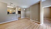 Located at 2201 Williams Glen Blvd in Zionsville, Indiana, this one-bedroom, one-bathroom residence offers a well-organized single-floor layout designed for comfortable everyday living. The living room serves as the heart of the unit, featuring light wood-style flooring, warm neutral-toned walls, and a glass-paneled entry door alongside a window that fills the space with natural light. Pendant lighting adds a finishing touch to the open feel of the area.

The galley-style kitchen is efficiently arranged with honey-toned wood cabinetry, dark granite-style countertops, and a full suite of black appliances including a refrigerator, electric range, dishwasher, and microwave. The kitchen opens toward a hallway leading to the rest of the unit, offering a practical and connected flow. A dedicated laundry area with a full-size washer and dryer is conveniently tucked nearby.

The bedroom is carpeted and comfortably sized, featuring a ceiling fan, a window with natural light, and access to a spacious walk-in closet with built-in shelving — providing ample storage. A second closet adds further organizational flexibility. The full bathroom includes a single-sink vanity with wood cabinetry and granite-style countertop, a tub/shower combo with tile surround, and light wood-style flooring consistent with the rest of the unit.