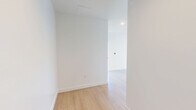 Located on Wilshire Boulevard in the heart of Los Angeles, this 1-bedroom, 1-bathroom residence offers a bright, modern living experience defined by clean lines and an open, airy layout. Light wood flooring flows seamlessly throughout the entire unit, complementing the crisp white walls and contemporary finishes.

The combined kitchen and living room serves as the heart of the space. The kitchen is equipped with stainless steel appliances — including a refrigerator, range, dishwasher, and microwave — set against white cabinetry and a subtle tile backsplash. The open living area is bathed in natural light, thanks to expansive floor-to-ceiling windows that frame sweeping views of the Los Angeles skyline and surrounding cityscape.

The bedroom offers a comfortable, well-proportioned retreat with a large walk-in closet featuring built-in shelving, a window providing natural light, and direct access to the hallway. The bathroom is finished in clean white tile, complete with a full soaking tub and shower combination, a vanity, and tile flooring. Two hallways connect the rooms efficiently, contributing to a logical and functional floor plan throughout this well-appointed urban residence.