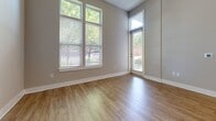 Located on Central Avenue in Charlotte's vibrant 28204 corridor, this modern 2-bedroom, 2-bathroom residence offers a thoughtfully designed single-level layout with contemporary finishes throughout. Warm wood-look flooring flows seamlessly across all living areas, complemented by neutral-toned walls and crisp white trim that create a clean, cohesive aesthetic.

The open-concept kitchen and living area serves as the heart of the home. The kitchen is appointed with sleek dark cabinetry, a white subway tile backsplash, stainless steel appliances — including a refrigerator, range, and microwave — and a large center island topped with granite that provides ample prep and dining space. Pendant lighting highlights the island, while soaring ceilings amplify the sense of openness.

The living area features tall windows and a glass door that invite generous natural light and views of the surrounding greenery, further enhancing the airy atmosphere.

Both bedrooms are well-proportioned with soft neutral walls and wood-look flooring, each served by its own dedicated walk-in closet with wire shelving systems offering versatile storage. The two bathrooms are finished with dark vanity cabinetry, granite countertops, and white subway tile tub surrounds, maintaining a consistent modern aesthetic. This residence delivers a polished, functional living experience in a prime Charlotte location.