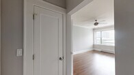 Located at 817 W Lakeside Pl in Chicago's Uptown neighborhood, this one-bedroom, one-bathroom unit offers a thoughtfully laid-out single-floor plan. Rich hardwood floors run throughout the entire space, lending warmth and continuity to every room.

The galley-style kitchen is efficiently designed with white cabinetry lining both sides, dark countertops, subway tile backsplash, and stainless steel appliances including a refrigerator, range, and over-the-range microwave. A vintage-style globe pendant light adds a classic touch overhead.

The open living area is bright and airy, featuring large windows that invite generous natural light and city views. Crown molding frames the ceilings, and a ceiling fan with a brushed nickel finish enhances the room's comfort. Baseboard heating runs along the walls, ensuring year-round climate control.

The bedroom is a comfortable size, featuring two windows with urban views, crown molding, a built-in closet, and a wall-mounted mini-split unit for independent climate control. Neutral gray walls throughout the unit create a clean, modern aesthetic.

The bathroom is finished with classic white subway tile surrounding the soaking tub, a basketweave-patterned tile floor, and a window providing natural ventilation. The layout also includes a dedicated entrance and hallway connecting all areas of the home seamlessly.