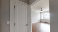 Located at 817 W Lakeside Pl in Chicago's Uptown neighborhood, this one-bedroom, one-bathroom unit offers a thoughtfully laid-out single-floor plan. Rich hardwood floors run throughout the entire space, lending warmth and continuity to every room.

The galley-style kitchen is efficiently designed with white cabinetry lining both sides, dark countertops, subway tile backsplash, and stainless steel appliances including a refrigerator, range, and over-the-range microwave. A vintage-style globe pendant light adds a classic touch overhead.

The open living area is bright and airy, featuring large windows that invite generous natural light and city views. Crown molding frames the ceilings, and a ceiling fan with a brushed nickel finish enhances the room's comfort. Baseboard heating runs along the walls, ensuring year-round climate control.

The bedroom is a comfortable size, featuring two windows with urban views, crown molding, a built-in closet, and a wall-mounted mini-split unit for independent climate control. Neutral gray walls throughout the unit create a clean, modern aesthetic.

The bathroom is finished with classic white subway tile surrounding the soaking tub, a basketweave-patterned tile floor, and a window providing natural ventilation. The layout also includes a dedicated entrance and hallway connecting all areas of the home seamlessly.
