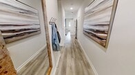This 920-square-foot, single-story apartment at Richmond in Tallahassee, FL, offers 2 bedrooms and 2 bathrooms designed with modern, contemporary finishes throughout. The open-concept kitchen and living area serves as the heart of the home, featuring white shaker cabinets, granite countertops, a kitchen island with bar seating, stainless steel appliances, and light wood-look flooring that extends throughout the unit. The living room is bright and airy, with large windows dressed in elegant drapes that allow ample natural light. The primary bedroom spans 170 square feet and includes a window with natural light and access to a spacious en-suite bathroom boasting a double-sink granite vanity, white cabinetry, and wood-look flooring. The second bedroom is well-sized and connects conveniently to a second full bathroom, which features a granite-top vanity, white cabinetry, and a shower/tub combo. A dedicated in-unit laundry area accommodates a full-size washer and dryer with overhead shelving for additional storage. A closet provides further storage solutions. The unit's clean, neutral color palette and consistent design language create a cohesive, modern ambiance throughout this well-appointed Tallahassee apartment.