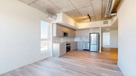 Located at 770 Somerset St W in Ottawa's vibrant Centretown neighbourhood, this 2-bedroom, 2-bathroom unit offers a compelling blend of modern finishes and industrial-inspired design. The open-concept living, dining, and kitchen area serves as the heart of the home, characterized by striking exposed concrete ceilings with visible ductwork that lend a loft-like aesthetic. Light hardwood flooring runs throughout, adding warmth and continuity across the space. The contemporary kitchen is well-appointed with sleek flat-front cabinetry in a warm grey tone, a white tile backsplash, and a full suite of stainless steel appliances including a built-in oven, microwave, dishwasher, and refrigerator. Large windows in the living area and bedrooms invite abundant natural light and offer open city views. The primary bedroom is a comfortable size and features a closet, while the second bedroom also benefits from natural light and exposed concrete ceiling details. Both bathrooms are finished with large-format floor tiles and include a soaker tub with a tiled surround. Additional conveniences include three closets and in-unit laundry. The unit's clean, neutral palette and modern construction make it a polished and functional urban residence.