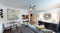 This studio is a thoughtfully designed single-floor residence that maximizes every square foot with an open-concept layout and modern aesthetic. The main living area features rich hardwood-style flooring, crisp white walls, and a ceiling fan with integrated lighting, creating a bright and comfortable atmosphere. A large piece of wall art adds a bold visual anchor to the living space, which flows seamlessly into a compact dining area — ideal for intimate gatherings.

The kitchen is partially open to the main living area, featuring dark cabinetry, a mosaic tile backsplash, and a pass-through counter that connects the cooking space to the rest of the unit. This design choice enhances the sense of openness while maintaining a defined kitchen zone.

A hallway leads to the bathroom, which is visible from the main living area and continues the clean, contemporary design language found throughout the space. The bathroom is efficiently laid out and finished with coordinating fixtures.

Throughout the studio, the cohesive design, smooth ceilings, and open sightlines contribute to an airy and livable feel that makes the space feel larger than its footprint. The overall ambiance is modern, polished, and well-suited for comfortable everyday living.