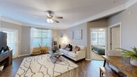 Located at 6771 W 138th Terrace in Overland Park, Kansas, this single-floor residence offers a thoughtfully designed layout with a cohesive, modern aesthetic. The open-concept living and dining area serves as the heart of the home, featuring warm hardwood-style flooring, crown molding, and a ceiling fan overhead. Multiple windows fitted with blinds and sheer curtains allow generous natural light to fill the space. A kitchen island with bar seating anchors the transition between the dining area and the galley-style kitchen, which is equipped with dark cabinetry, granite countertops, a white subway tile backsplash, and a full suite of stainless steel appliances.

The primary bedroom is generously proportioned, with plush carpeting, multiple windows, and a ceiling fan. Its en-suite bathroom features a single vanity with granite countertops, dark cabinetry, and a tub-shower combination, with direct access to a spacious walk-in closet with built-in shelving. A second bedroom, also carpeted and ceiling fan-equipped, offers comfortable accommodations. A full bathroom with similar finishes serves additional needs. Throughout, neutral warm-gray tones and consistent design details create a unified and inviting atmosphere.