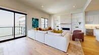 Located at 3111 Sunset Blvd in Flower Mound, TX, this expansive single-story residence offers a refined modern living experience across three bedrooms, five bathrooms, and a thoughtfully curated floor plan. The open-concept living room serves as a centerpiece, featuring a dramatic floor-to-ceiling stone fireplace flanked by built-in shelving, creating an elegant yet inviting focal point. The chef's kitchen is outfitted with crisp white shaker cabinetry, quartz countertops, professional-grade stainless steel appliances, a gas range, and a wine cooler — all set atop warm hardwood flooring. The dining room offers sweeping lake views through oversized black-framed windows, complemented by rich hardwood floors and space for generous entertaining. The dedicated office captures breathtaking waterfront views, filling the room with natural light. The spacious primary suite features direct lake views, a ceiling fan, and a luxurious en-suite bathroom complete with a freestanding soaking tub, glass-enclosed marble shower, and bold navy cabinetry with gold fixtures. Three well-organized walk-in closets and a well-appointed laundry room with marble-look tile flooring and ample cabinetry round out this meticulously designed home.
