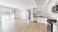 Located at 744 Hartford Ave in Los Angeles, CA, this 2-bedroom, 2-bathroom unit offers a thoughtfully designed single-floor layout with a clean, modern aesthetic. Light wood-tone flooring runs throughout the space, complementing the crisp white walls and creating a bright, cohesive atmosphere.

The open-concept kitchen and living area serves as the heart of the home. The kitchen is well-appointed with white shaker-style cabinetry, herringbone tile backsplash, stone-look countertops, and a full suite of stainless steel appliances including a gas range, microwave, dishwasher, and refrigerator. A sliding glass door in the living area provides access to a balcony and allows natural light to fill the space.

The primary bedroom offers a comfortable footprint with a mirrored sliding-door closet featuring built-in shelving. The second bedroom, bright with a large window overlooking the exterior, provides flexibility as a guest room or home office.

Both bathrooms are finished with wood-tone vanity cabinetry, stone-look countertops, large mirrors, and tub-shower combinations with sliding glass enclosures. A hallway with a double-door closet provides additional storage. Recessed lighting and neutral tones throughout lend the space a polished, move-in-ready character.