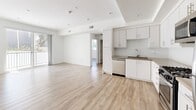 Located at 744 Hartford Ave in Los Angeles, CA, this 2-bedroom, 2-bathroom unit offers a thoughtfully designed single-floor layout with a clean, modern aesthetic. Light wood-tone flooring runs throughout the space, complementing the crisp white walls and creating a bright, cohesive atmosphere.

The open-concept kitchen and living area serves as the heart of the home. The kitchen is well-appointed with white shaker-style cabinetry, herringbone tile backsplash, stone-look countertops, and a full suite of stainless steel appliances including a gas range, microwave, dishwasher, and refrigerator. A sliding glass door in the living area provides access to a balcony and allows natural light to fill the space.

The primary bedroom offers a comfortable footprint with a mirrored sliding-door closet featuring built-in shelving. The second bedroom, bright with a large window overlooking the exterior, provides flexibility as a guest room or home office.

Both bathrooms are finished with wood-tone vanity cabinetry, stone-look countertops, large mirrors, and tub-shower combinations with sliding glass enclosures. A hallway with a double-door closet provides additional storage. Recessed lighting and neutral tones throughout lend the space a polished, move-in-ready character.