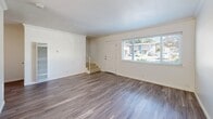 Located in Castro Valley, CA, this two-story, 2-bedroom, 2-bathroom home offers a well-designed layout spread evenly across two floors. The main level features a bright, open living room with wood-style laminate flooring, crown molding, and a large window that fills the space with natural light. A staircase connects to the upper level, while a sliding glass door off the kitchen area leads to a private outdoor patio.

The kitchen is a standout feature, showcasing white shaker-style cabinetry, dark granite countertops, a mosaic tile backsplash, and stainless steel appliances including a refrigerator, dishwasher, and range. Wood-style flooring continues throughout the kitchen and dining area.

Upstairs, both bedrooms are carpeted and feature crown molding, mirrored sliding closet doors, and windows that invite natural light. The spacious primary bedroom offers a generous footprint with ample closet space. Both bathrooms are finished with wood-style flooring and bright white fixtures; one includes a full tub-shower combo with white tile surround and a window for ventilation.

Clean, neutral finishes throughout create a cohesive and move-in-ready aesthetic, making this Castro Valley home a practical and comfortable residence.