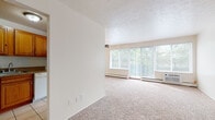 This single-floor residence at 6440 Pearl Rd in Parma Heights, Ohio offers a straightforward, functional layout with well-defined living spaces throughout. The floor plan, as revealed by the 3D model, arranges rooms efficiently across one level, connecting living, sleeping, kitchen, and bathroom areas in a cohesive design.

The living area is a standout feature, bathed in natural light from a large picture window and an expansive sliding glass door fitted with vertical blinds. A ceiling fan with integrated lighting provides both comfort and illumination, while baseboard heating units run along the exterior walls. Neutral beige carpeting covers the floor, contributing to a warm, understated ambiance.

The bedroom continues the carpeted flooring and features a sliding-door closet with a built-in rod and shelf, offering practical storage. A dedicated entry area leads from the front door into the main living space.

The kitchen is equipped with warm-toned wood cabinetry, a white electric range, a sink, and light tile flooring that contrasts with the carpeted areas elsewhere.

The bathroom includes tile flooring, white square wall tile wainscoting, and a tub-shower combination, presenting a clean and functional design. Throughout the unit, the neutral color palette and abundant natural light create a bright, open atmosphere.